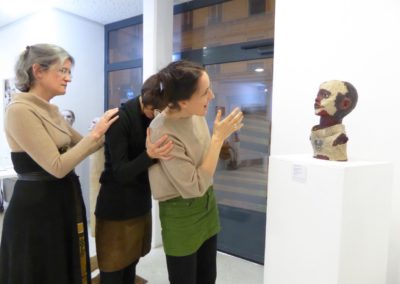 Drei Sängerinnen im Profil improvisieren vor Skulptur (Kinderkopf) in Galerie