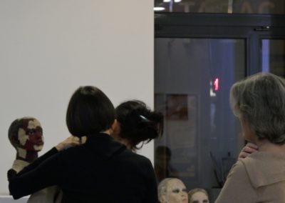Drei Sängerinnen improvisieren vor Skulpturen in Galerie, Rückenaufnahme
